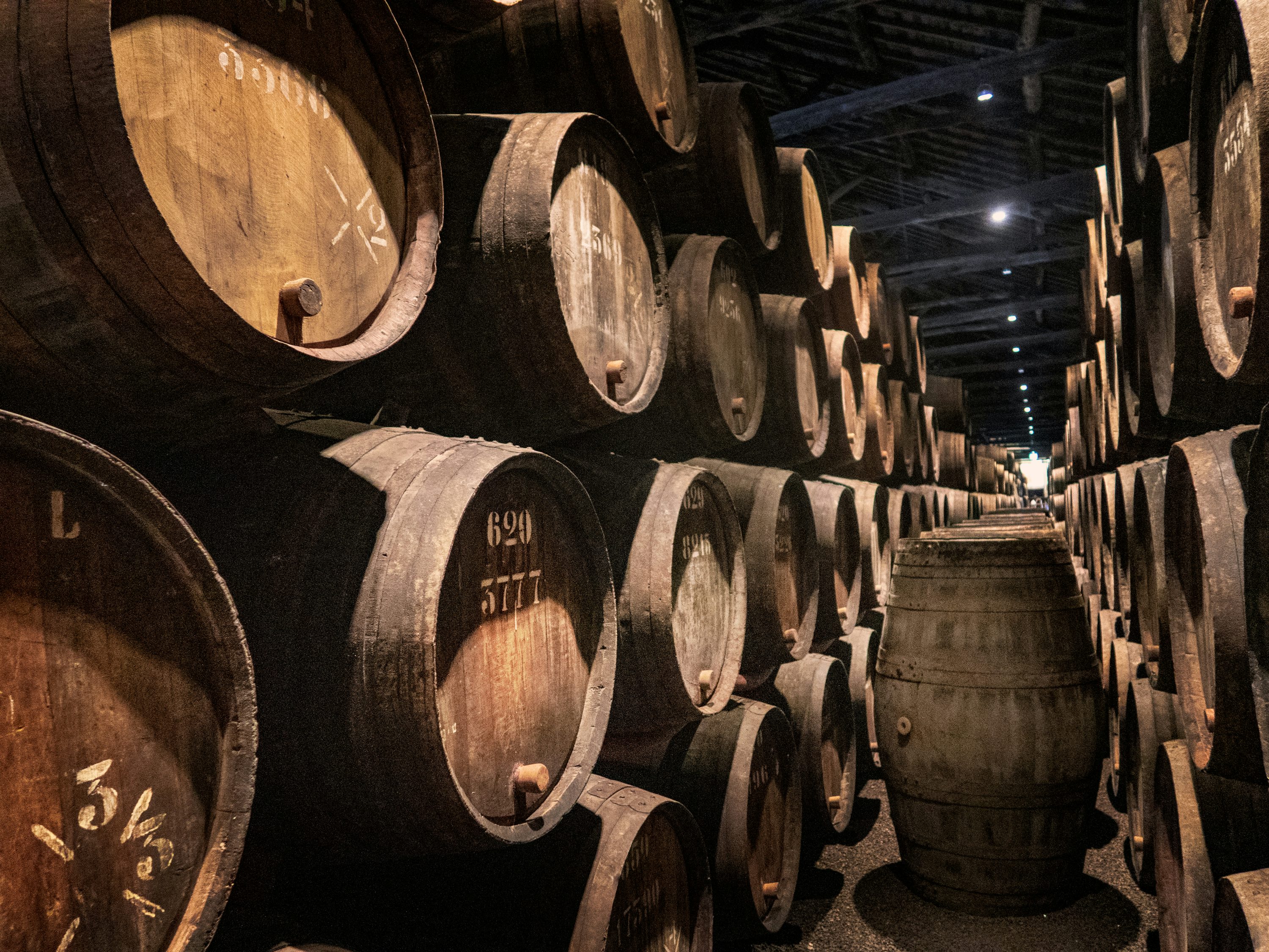 Rows of whisky casks in a warehouse aisle