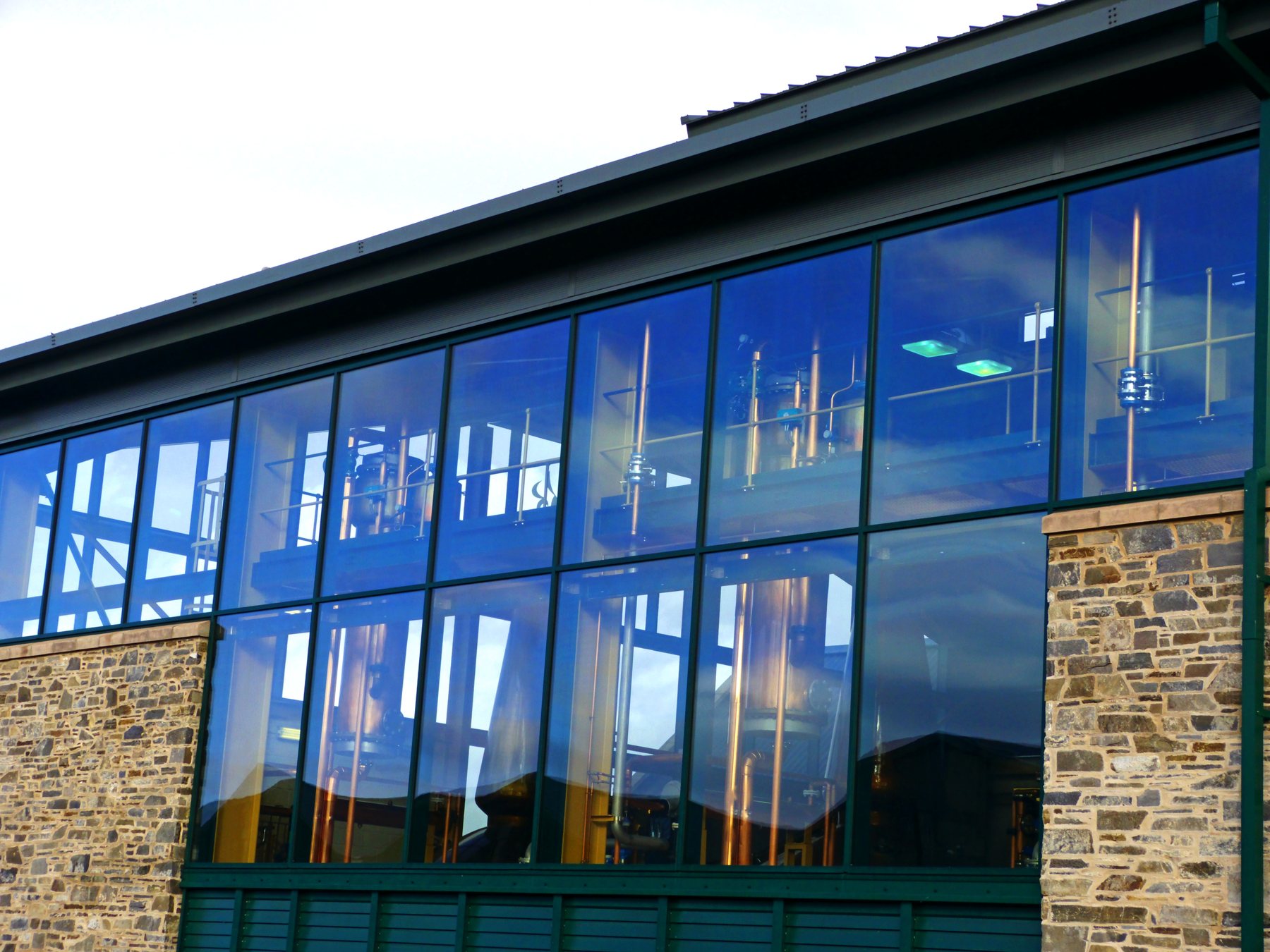 Copper stills visible through The Glenlivet distillery process building